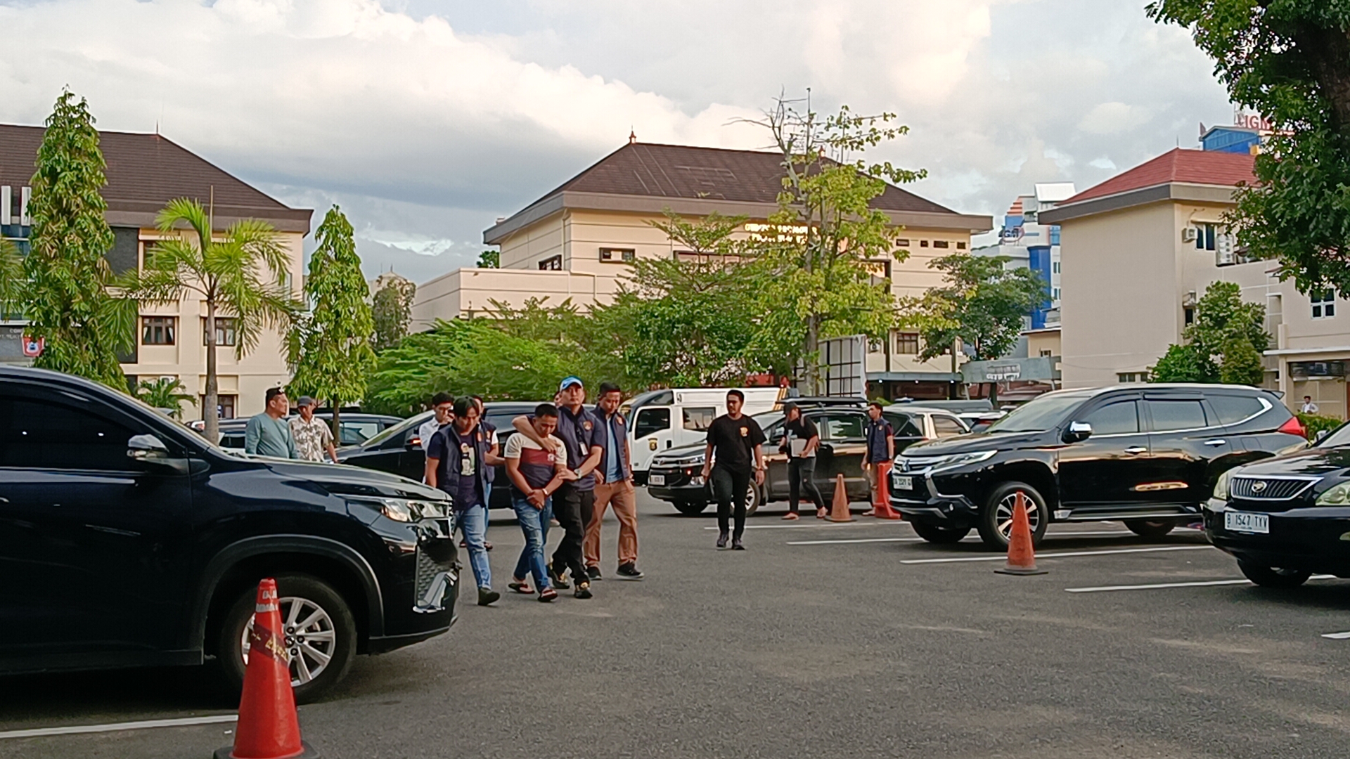 Kasubdit IV Tipidter Ditreskrimsus Polda Sumsel AKBP Ahmad Budi Martono didampingi Kanit II Tipiter Kompol M Indra Parameswara, saat membawa pelaku R ke Gedung Ditreskrimsus Polda Sumsel, Senin (13/4/26).Fhoto: Suherman 