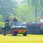 Kapolda Sumsel, Irjen Pol Sandi Nugroho bersama Gubernur Sumsel, H Herman Deru menaiki mobil komando untuk mengecek pasukan upacara di acara peringatan HUT Bhayangkara ke 80, Selasa (1/7/26). Fhoto: Istimewa