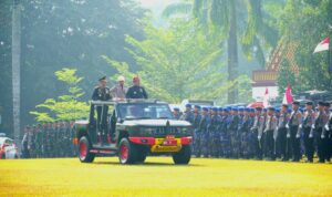 Kapolda Sumsel, Irjen Pol Sandi Nugroho bersama Gubernur Sumsel, H Herman Deru menaiki mobil komando untuk mengecek pasukan upacara di acara peringatan HUT Bhayangkara ke 80, Selasa (1/7/26). Fhoto: Istimewa