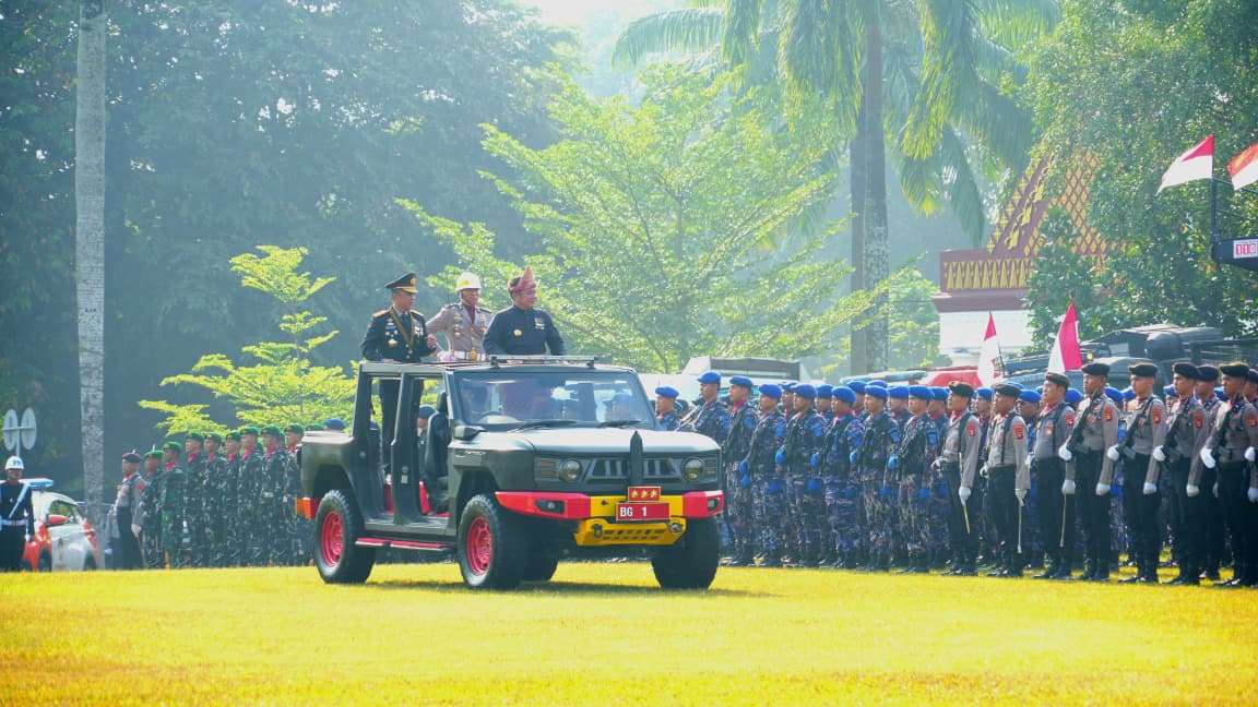 Kapolda Sumsel, Irjen Pol Sandi Nugroho bersama Gubernur Sumsel, H Herman Deru menaiki mobil komando untuk mengecek pasukan upacara di acara peringatan HUT Bhayangkara ke 80, Selasa (1/7/26). Fhoto: Istimewa